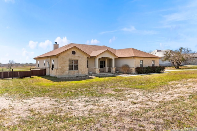 rear view of property featuring fence, a lawn, and a chimney