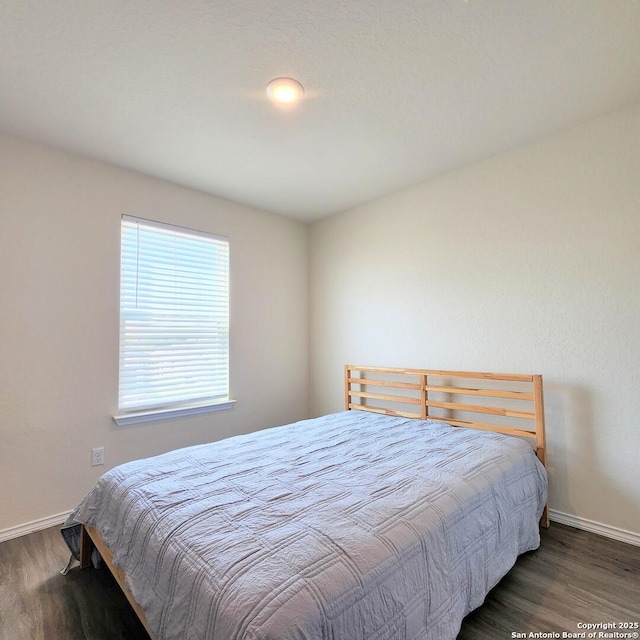 bedroom featuring baseboards and wood finished floors