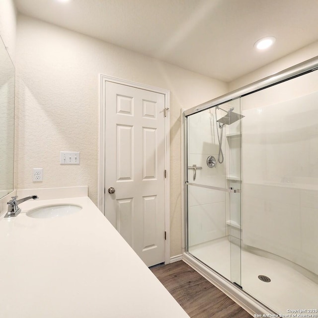 bathroom featuring vanity, recessed lighting, wood finished floors, and a stall shower