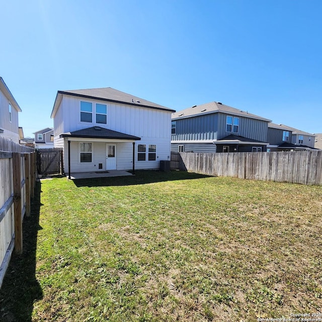 back of property with a patio area, a yard, and a fenced backyard