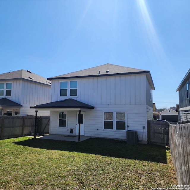 rear view of property with a patio area, central air condition unit, a lawn, and a fenced backyard