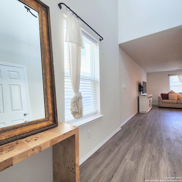 hallway featuring baseboards and wood finished floors