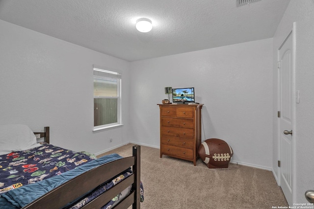 carpeted bedroom with baseboards and a textured ceiling