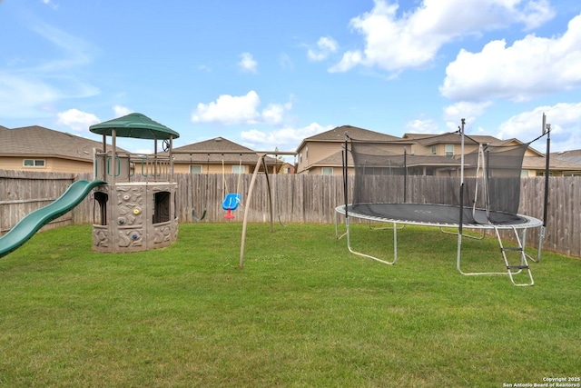 view of yard featuring a fenced backyard, a playground, and a trampoline