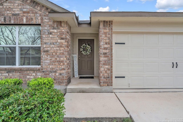 entrance to property featuring brick siding and an attached garage