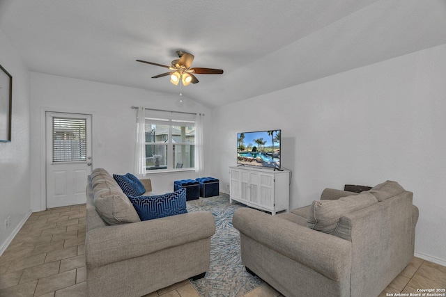 living area featuring lofted ceiling, baseboards, and ceiling fan