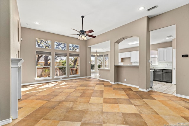 unfurnished living room featuring baseboards, visible vents, recessed lighting, a sink, and ceiling fan with notable chandelier