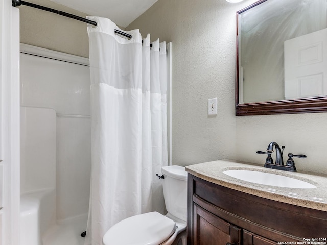 bathroom featuring toilet, vanity, a shower with curtain, and a textured wall