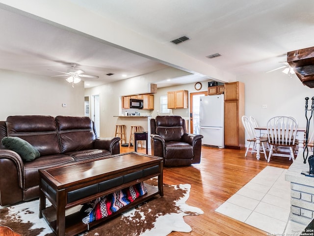 living area with visible vents, light wood-type flooring, and ceiling fan