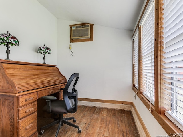 office featuring a wall mounted air conditioner, baseboards, wood finished floors, and vaulted ceiling