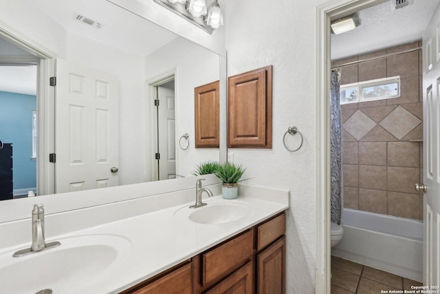 bathroom featuring tile patterned flooring, toilet, visible vents, and a sink