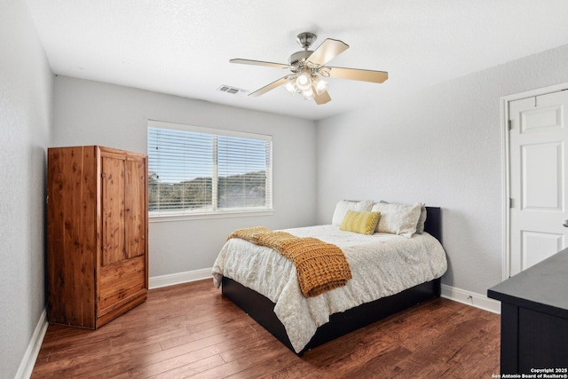 bedroom with visible vents, dark wood-style floors, baseboards, and ceiling fan