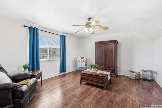 sitting room with lofted ceiling, baseboards, dark wood-style flooring, and ceiling fan