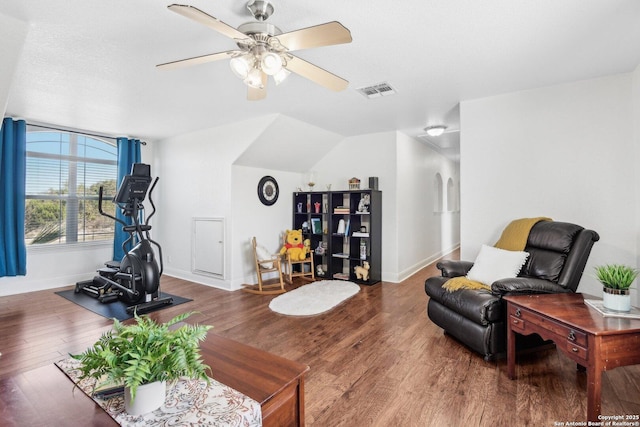 living room featuring baseboards, wood finished floors, visible vents, and ceiling fan