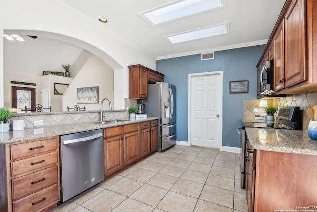 kitchen featuring a sink, stainless steel appliances, decorative backsplash, and crown molding