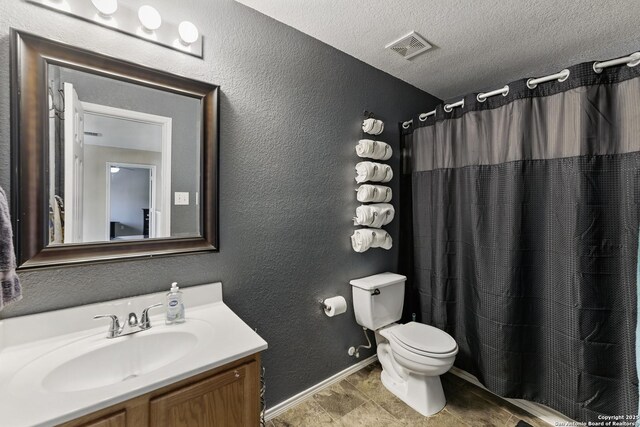 full bathroom featuring a textured ceiling, visible vents, toilet, and a textured wall