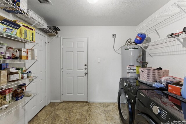 laundry room featuring electric water heater, baseboards, washing machine and dryer, laundry area, and a textured ceiling