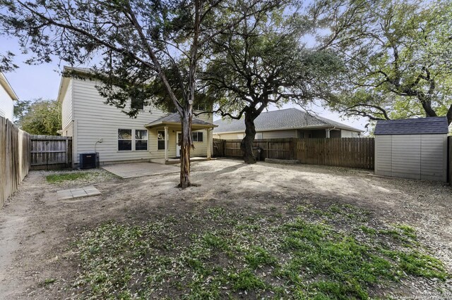 rear view of property featuring a fenced backyard, a patio, an outdoor structure, and a shed