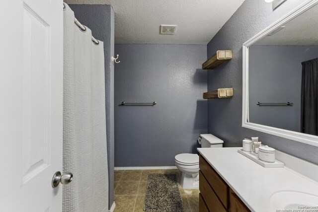 bathroom with visible vents, baseboards, toilet, vanity, and a textured ceiling