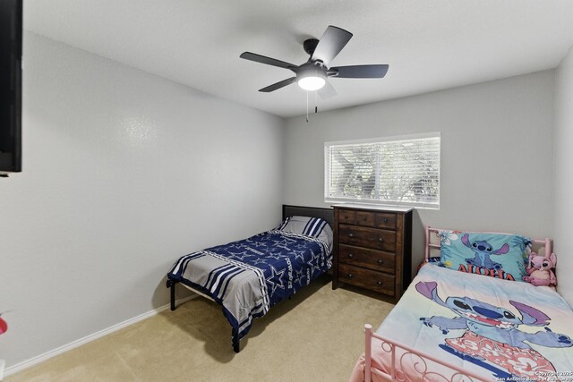 carpeted bedroom with baseboards and ceiling fan