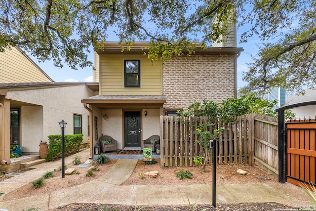 traditional-style home featuring stucco siding and fence