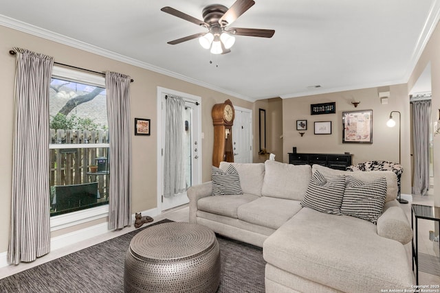 living area with visible vents, baseboards, crown molding, and a ceiling fan