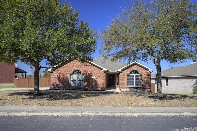 single story home featuring brick siding and fence