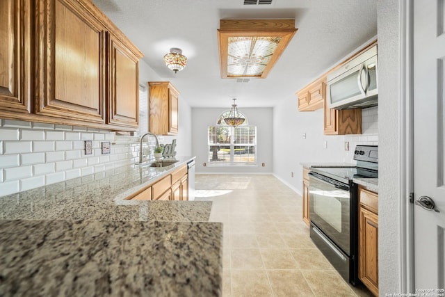 kitchen with baseboards, a sink, black range with electric cooktop, stainless steel microwave, and tasteful backsplash