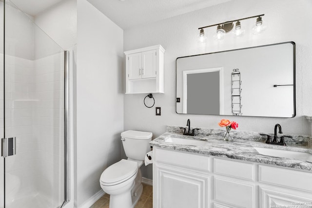 bathroom featuring double vanity, toilet, a stall shower, and a sink