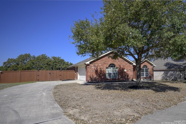 ranch-style home with a gate, fence, concrete driveway, a garage, and brick siding