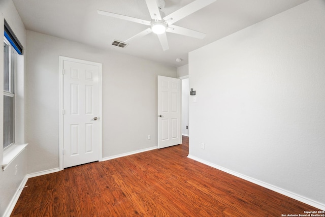 unfurnished bedroom featuring visible vents, baseboards, wood finished floors, and a ceiling fan