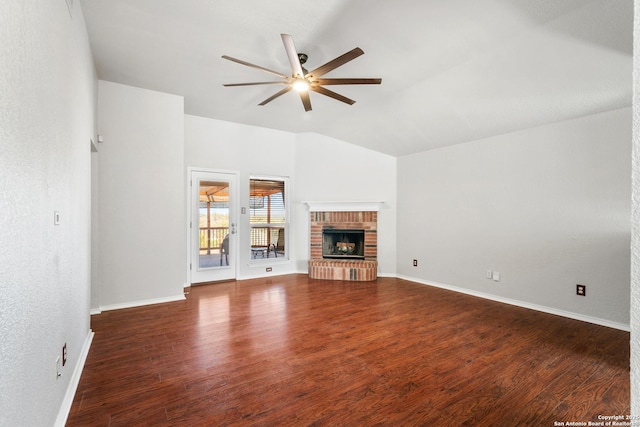 unfurnished living room featuring lofted ceiling, a ceiling fan, wood finished floors, baseboards, and a brick fireplace