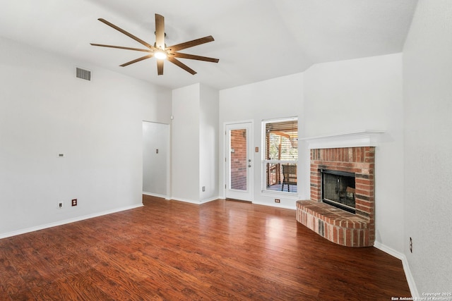 unfurnished living room featuring wood finished floors, baseboards, visible vents, a fireplace, and ceiling fan