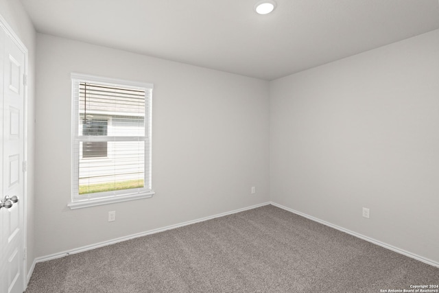 unfurnished room with baseboards and carpet