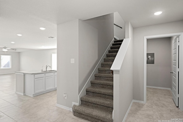 stairs featuring electric panel, visible vents, baseboards, and recessed lighting