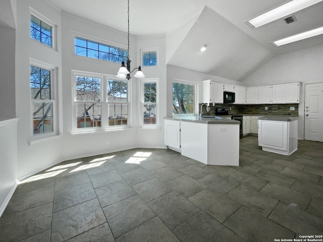 kitchen with a sink, dark countertops, electric range oven, white cabinetry, and black microwave