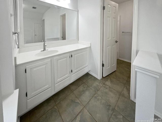 bathroom featuring vanity, visible vents, and baseboards