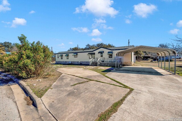 manufactured / mobile home featuring a detached carport and driveway