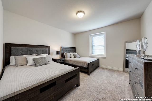 bedroom featuring baseboards and light carpet