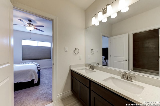 ensuite bathroom with double vanity, connected bathroom, and a sink