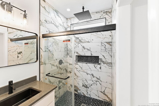 full bathroom featuring a marble finish shower and vanity