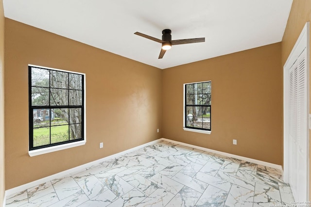 unfurnished bedroom with baseboards, marble finish floor, a closet, and ceiling fan