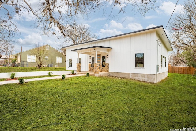 view of front facade featuring a front lawn, fence, and board and batten siding