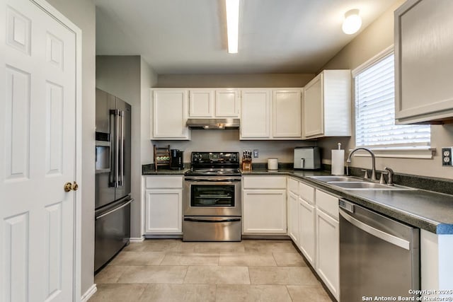 kitchen with a sink, stainless steel appliances, white cabinets, under cabinet range hood, and dark countertops