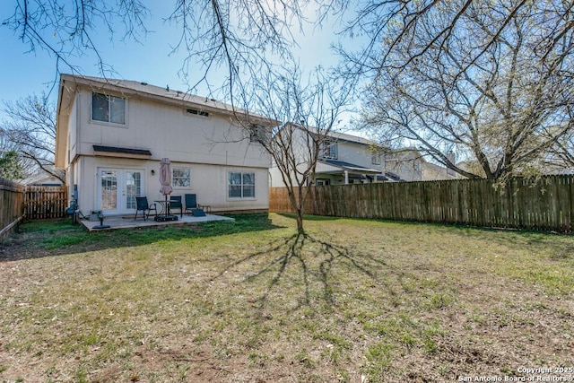 rear view of property with a patio, a fenced backyard, a lawn, and french doors