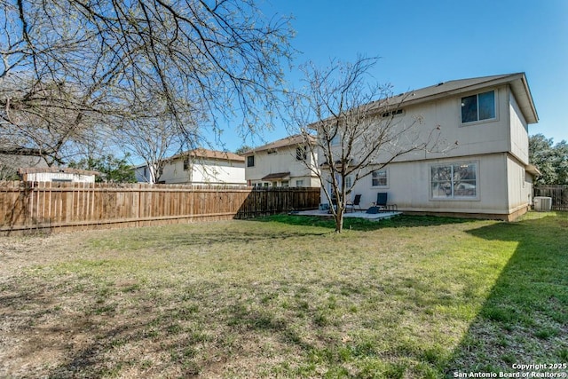 rear view of house with a yard, central air condition unit, a fenced backyard, and a patio area