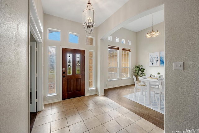 14019 Tahoe Vis, San Antonio, TX 78253 - entryway with light wood-type flooring, a chandelier, a textured wall, a high ceiling, and arched walkways