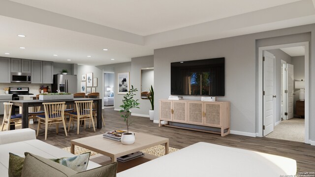 living area with recessed lighting, baseboards, and wood finished floors