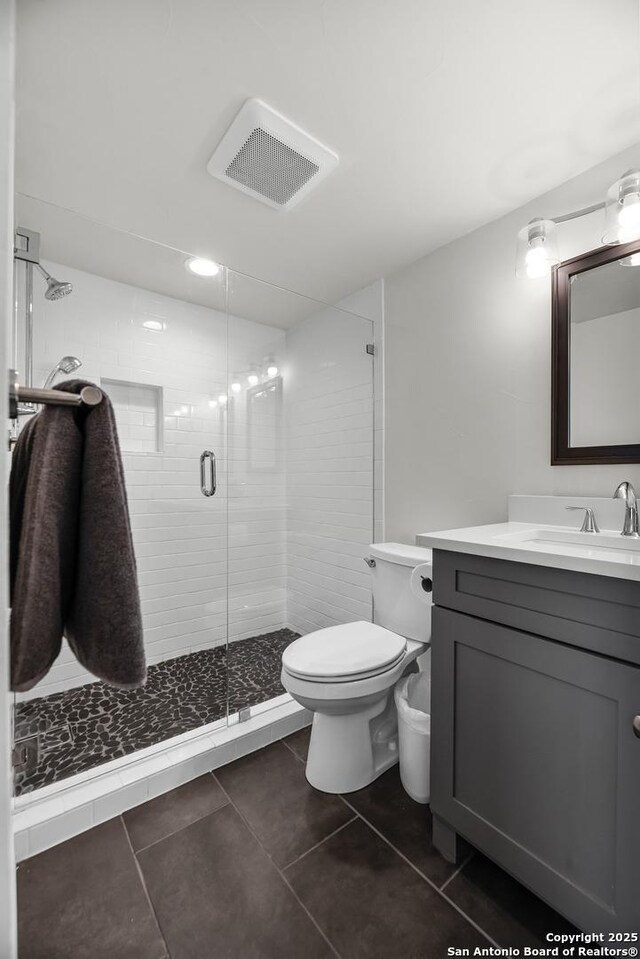 217 T Bar M # B21, New Braunfels, TX 78132 - bathroom featuring visible vents, toilet, a shower stall, tile patterned flooring, and vanity