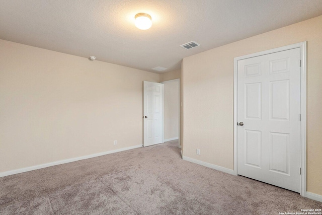 12604 Brite Rnch, San Antonio, TX 78245 - unfurnished bedroom with carpet flooring, visible vents, baseboards, and a textured ceiling